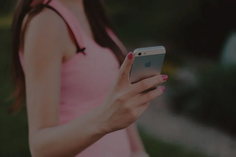 Woman holding a smartphone while using the First National Bank of Brookfield mobile app My Card feature. The image highlights convenient mobile banking tools that allow customers to manage their debit card directly from their phone.