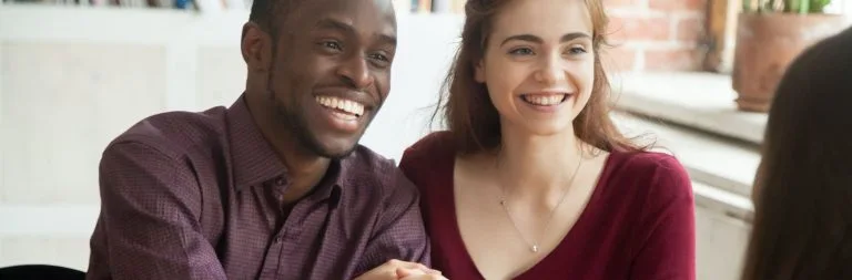 A happy couple meeting with a banker.
